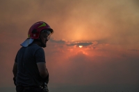 A member of emergency services looks on as a wildfire burns in Kurbin, Albania, on Tuesday. | REUTERS