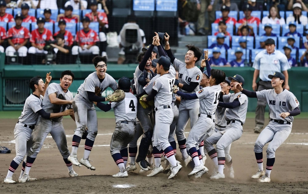 Keio High School players celebrate after topping Sendai Ikuei High School in the finals of the national high school baseball tournament at Koshien Stadium on Wednesday. 