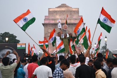 People wave Indian national flags as they celebrate the successful lunar landing of Chandrayaan-3 spacecraft on the south pole of the moon, in New Delhi on Wednesday. 