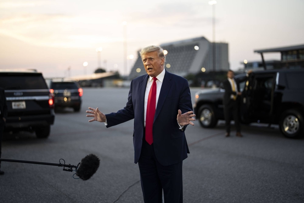 Donald Trump speaks to reporters before boarding his private plane at Hartsfield-Jackson International Airport in Atlanta on Thursday, where he turned himself in at the Fulton County Jail earlier in the evening. 