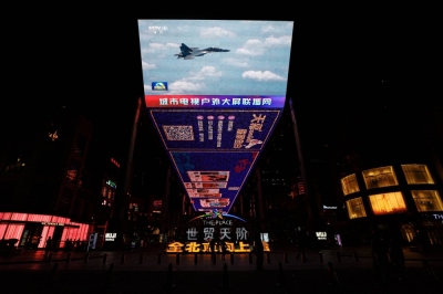A giant screen broadcasts news footage of a Chinese fighter jet taking part in a "combat readiness patrol" around Taiwan, at a shopping area in Beijing, in April.