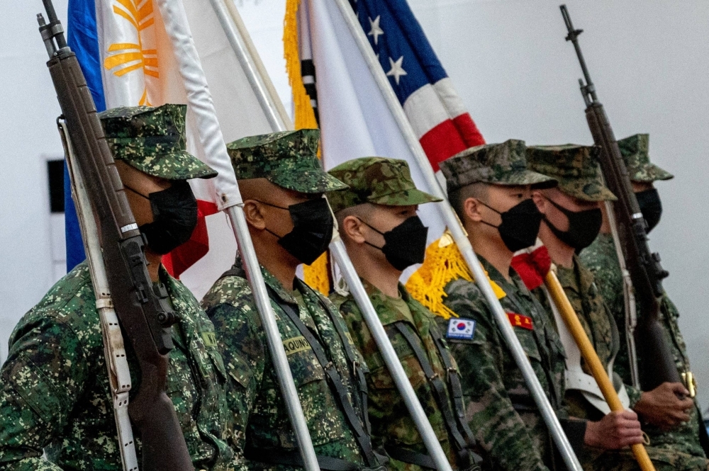 Members of the Philippines, Japan, South Korea, and U.S. armed forces carry national flags during the opening ceremony of joint military exercises in Taguig, Philippines, in October 2022. 
