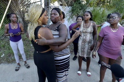Residents embrace after a deadly shooting in Jacksonville, Florida, killed three. 
