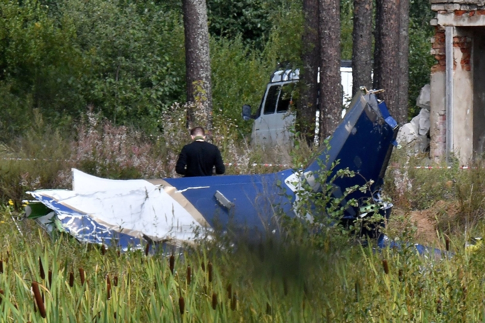 A law enforcement officer works at the site of a plane crash near the village of Kuzhenkino, Russia. Wagner chief Yevgeny Prigozhin was believed to be on board the plane and is presumed dead. 