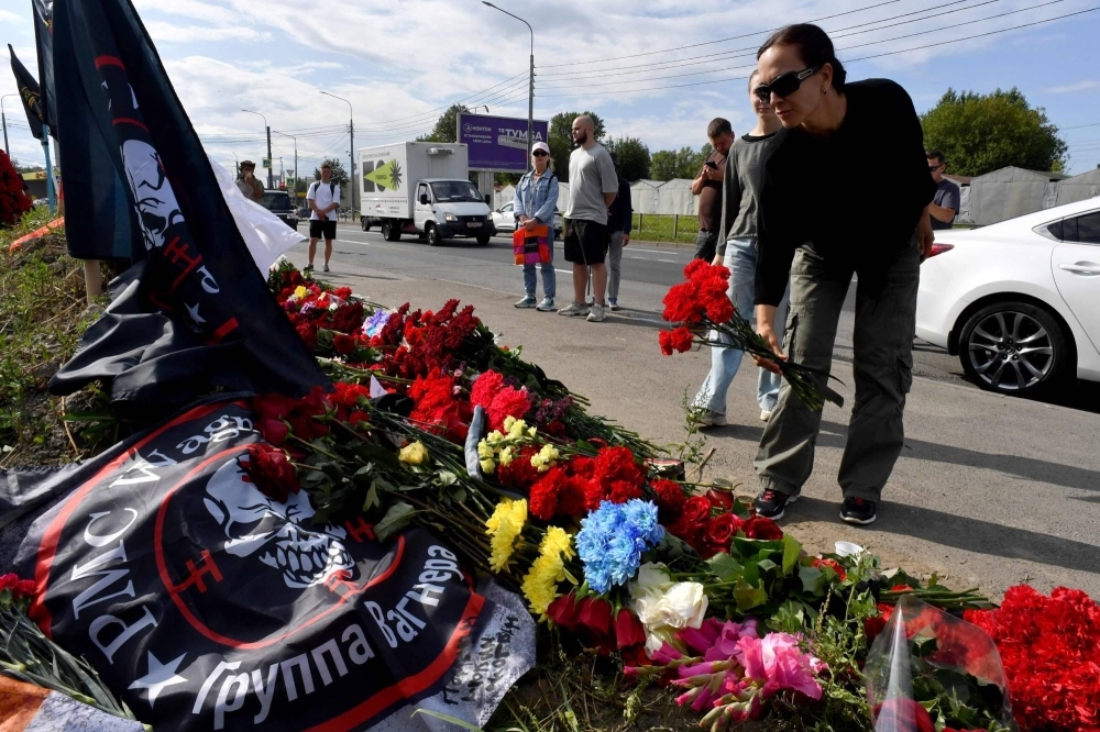 A woman lays flowers at a makeshift memorial for Yevgeny Prigozhin in Saint Petersburg, Russia, on Friday. 

 
