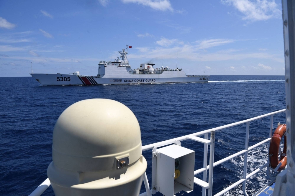 A Chinese coast guard ship (top) shadows a Philippine re-supply vessel on Tuesday in the disputed South China Sea.   