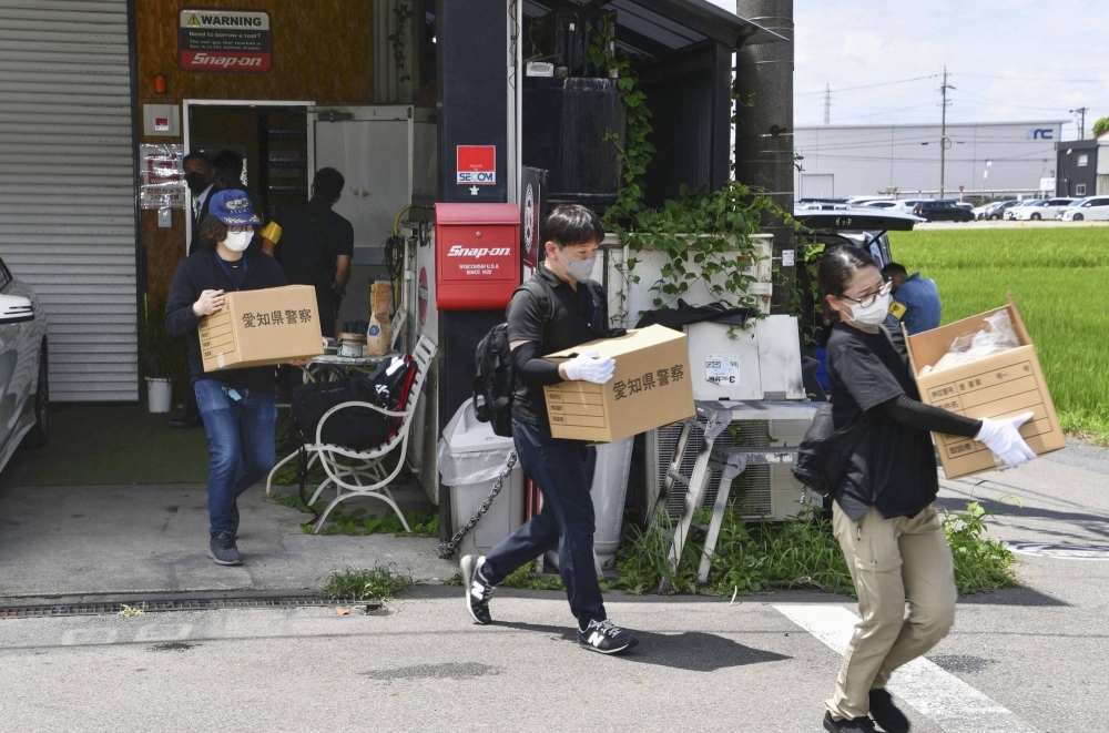 Aichi Prefectural Police investigators raid a car dealership in Komaki in August last year.