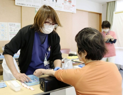 A woman takes a blood test to check concentrations of PFAS chemicals in February in the city of Fuchu, Tokyo.