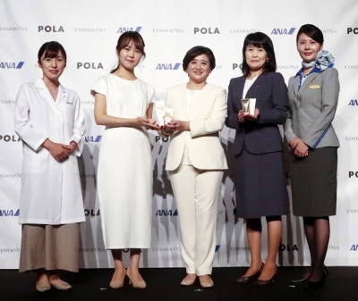 Pola President Miki Oikawa (center) unveils skincare products designed for use in outer space's low-gravity during an event in Tokyo on Monday.