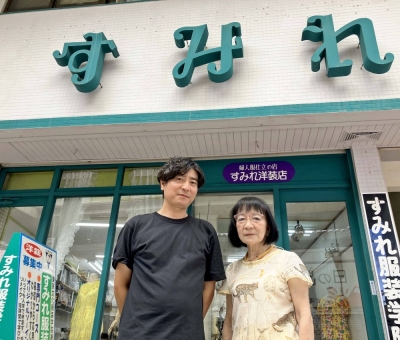 Kyoko Yafuso and her son Keiju Togei pose in front of their store in the Sunrise Naha shopping street.