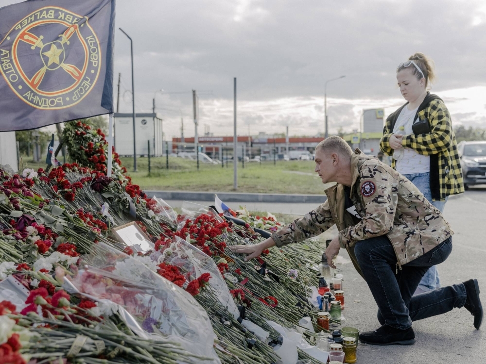A man in a jacket with a Wagner patch visits an impromptu memorial to Yevgeny Prigozhin and other Wagner "heroes,” near the mercenary group’s headquarters in St. Petersburg, Russia, on Tuesday.