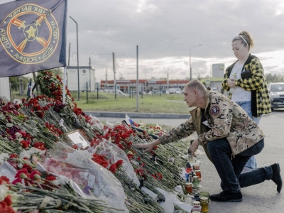 A man in a jacket with a Wagner patch visits an impromptu memorial to Yevgeny Prigozhin and other Wagner "heroes,” near the mercenary group’s headquarters in St. Petersburg, Russia, on Tuesday.