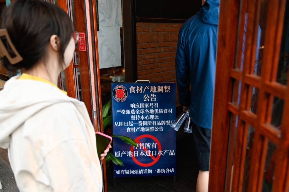 A sign reading "suspend the sale of all fish products imported from Japan" in an area of Japanese restaurants in Beijing