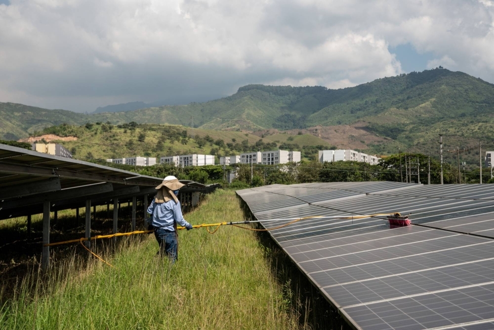 A worker cleans solar panels at a solar farm facility in Yumbo, Colombia.