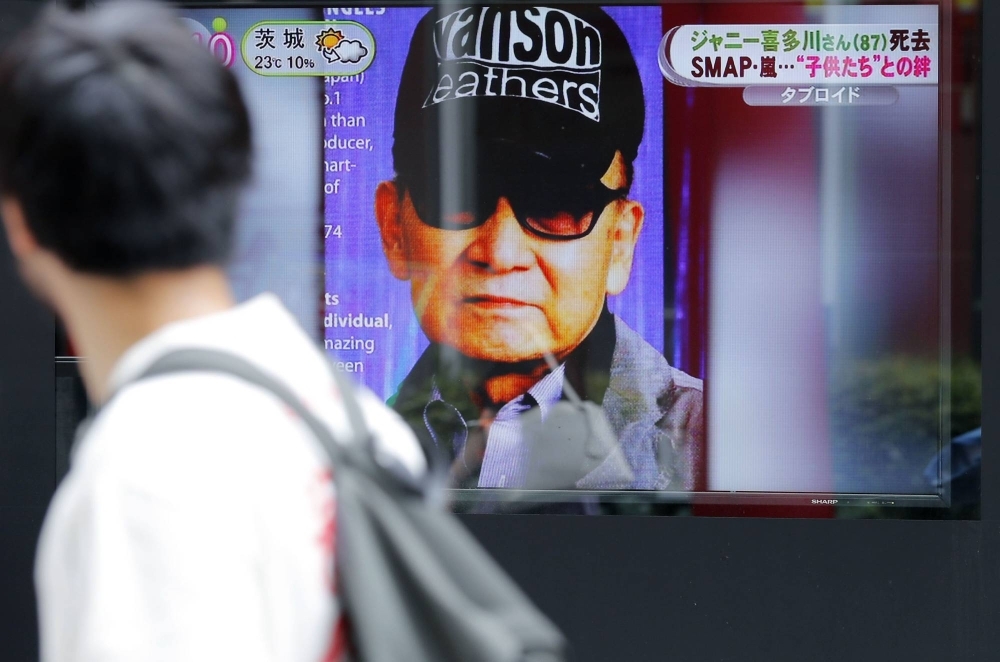 A monitor displays a news report about the death of Johnny Kitagawa in July 2019.