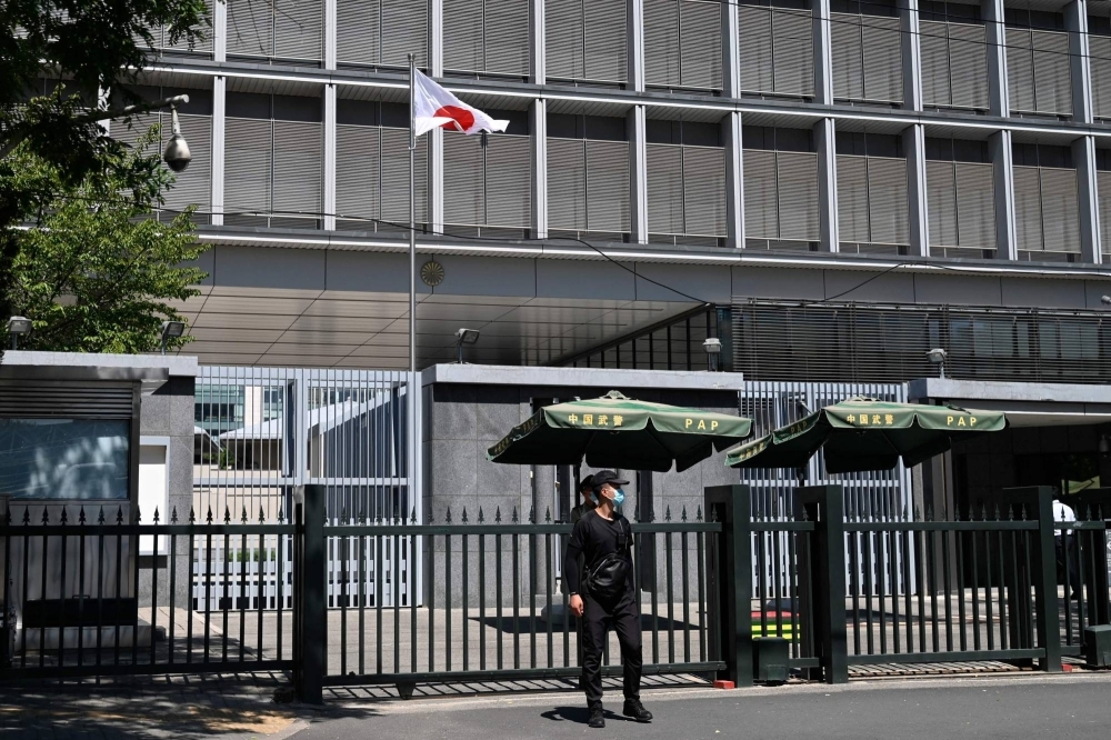 Police and security personnel stand outside the entrance of the Japanese Embassy in Beijing on Tuesday. Japan said that harassment being faced by its citizens in China after the Fukushima water release was "extremely regrettable," confirming that a brick was thrown at the country's embassy in Beijing.