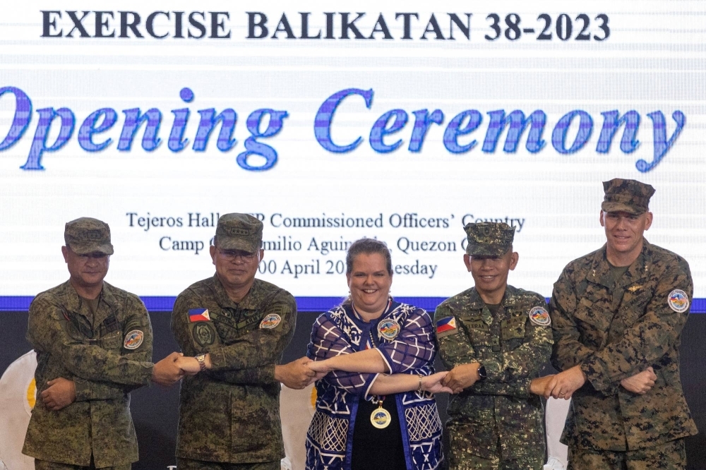 U.S and Philippine military officials link arms with U.S. Embassy representative Heather Variava during the opening ceremony of the annual Philippines-U.S. joint military exercises at the Armed Forces of the Philippines headquarters in Quezon City, Metro Manila, Philippines, on April 11.