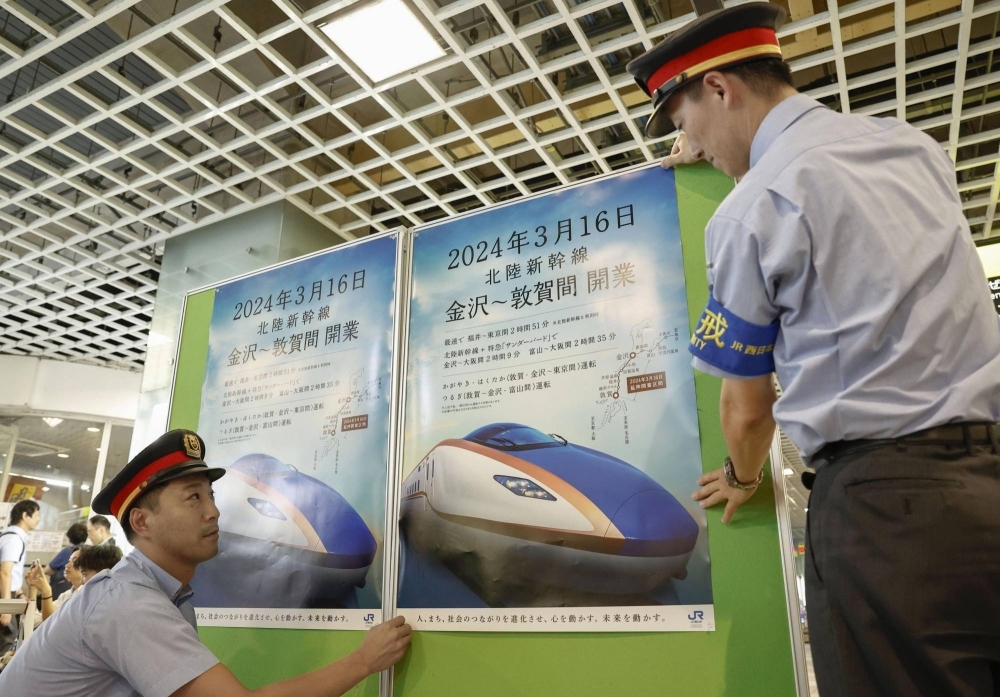 Staff put up posters about the extension of the Hokuriku Shinkansen Line at JR Fukui Station on Wednesday.