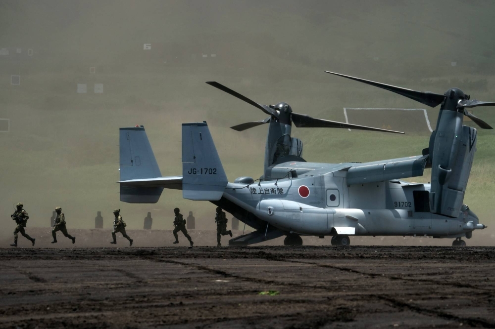 Members of the Ground Self-Defense Force disembark from a V-22 Osprey aircraft during a live-fire exercise in Gotemba, Shizuoka Prefecture, in May 2022.