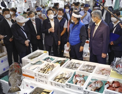 Prime Minister Fumio Kishida (center) visits a seafood wholesaler at Tokyo's Toyosu fish market on Thursday.