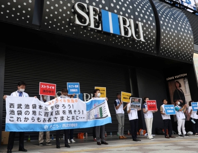 Union workers of Sogo & Seibu hold banners which read 'on strike' in front of the company's flagship Seibu Ikebukuro store in Tokyo on Thursday.