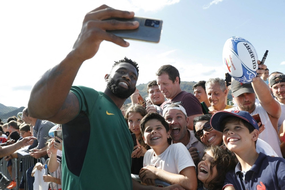 South Africa's Siya Kolisi takes selfies with fans after a practice session in Corsica on Aug. 29.