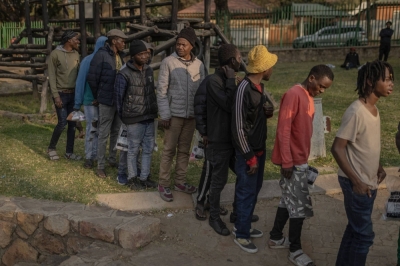 Survivors of the fire that ripped through the five-story building in the early hours on Thursday, killing 74 people, wait in line to receive donated food at a provisional shelter in Johannesburg on Friday.