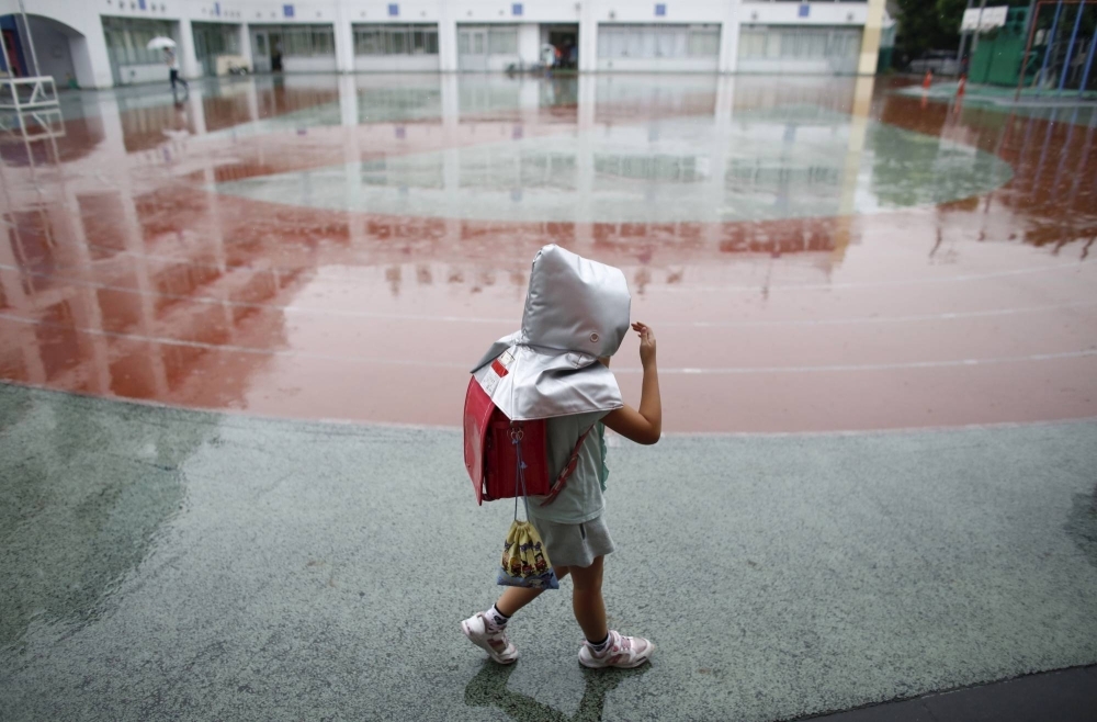 A schoolgirl wears a padded hood for protection from falling debris during an earthquake simulation exercise at an elementary school in Tokyo. The government estimates a 70% chance of a magnitude 7 event striking directly underneath the capital in the next 30 years.
