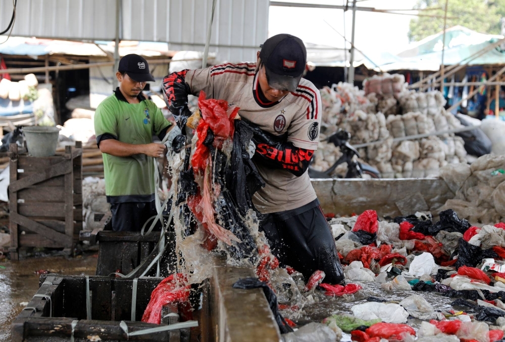 Workers clean and prepare plastic collected at a landfill for transport to a recycling plant in Bekasi, West Java province, near Jakarta.
