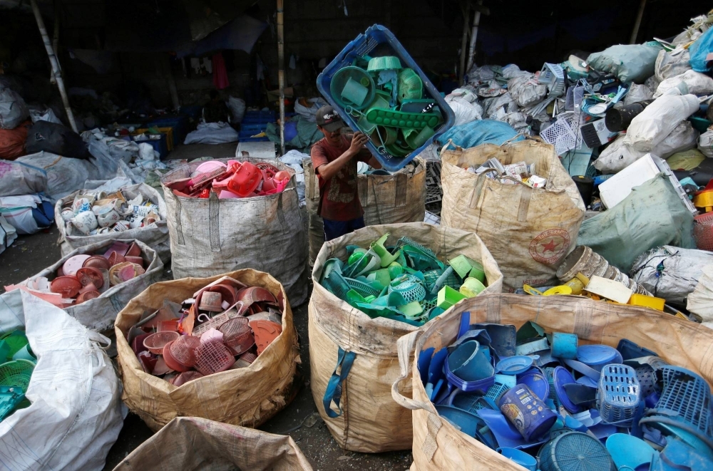 A worker sorts used plastic at a recycling center in Jakarta