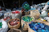 A worker sorts used plastic at a recycling center in Jakarta | Reuters