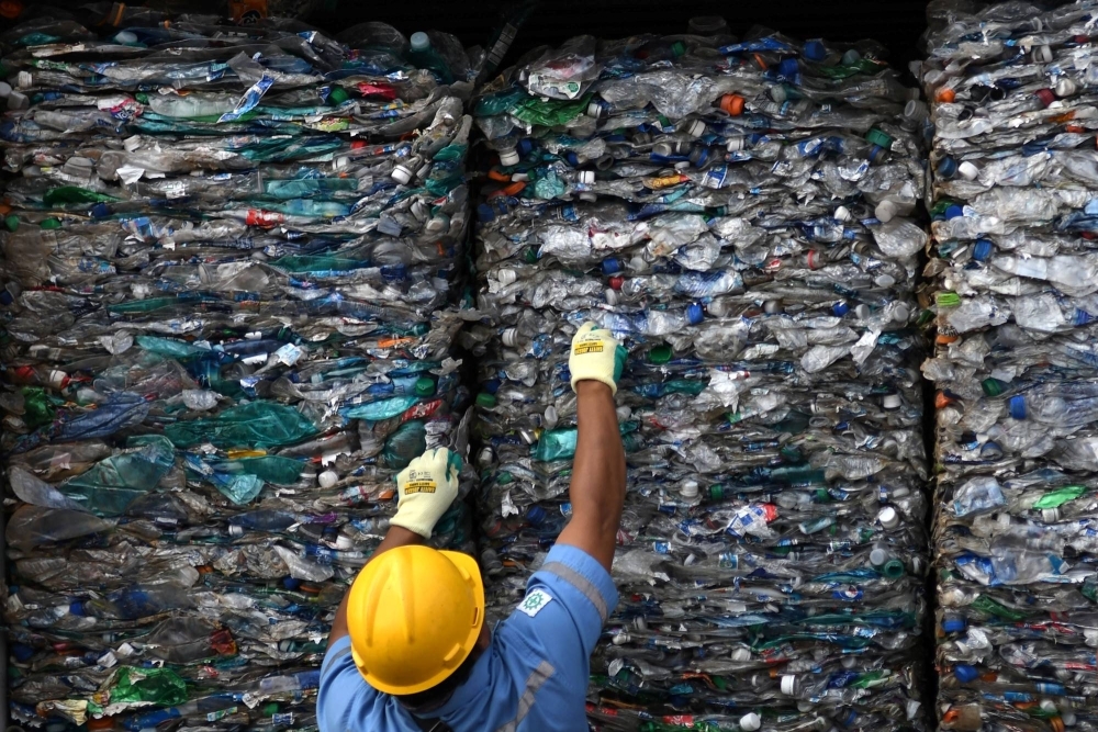 An officer shows a container full with plastic waste at a port in Jakarta