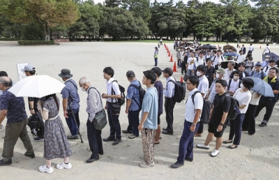 People line up Tuesday for a lottery to get a seat for the first trial hearing of Shinji Aoba, the suspect in the 2019 Kyoto Animation arson attack, at the Kyoto District Court.