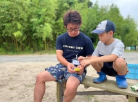 Futoshi Aizawa teaches one of Odyssey's young participants how to build a fire for outdoor cooking in Higashimatsushima, Miyagi Prefecture, last year.  | Odyssey 
