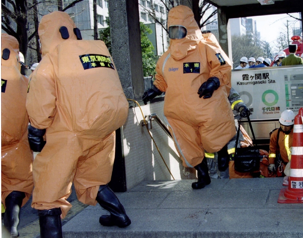 Special chemical control unit members emerge from an entrance to Kasumigaseki subway station in Tokyo on March 20, 1995. The Aum Shinrikyo cult released sarin nerve agent on several trains in Tokyo that day, killing 13 people.