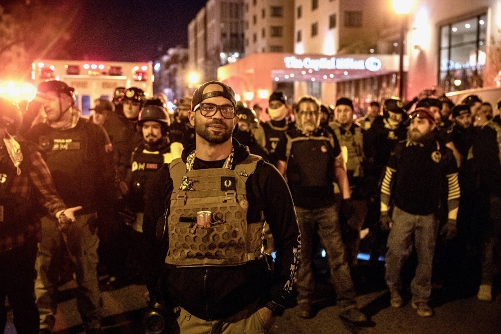 Enrique Tarrio (center) leads members of the far-right Proud Boys in protesting President Donald Trump's election defeat, in Washington in December 2020. Tarrio was sentenced to 22 years in prison for the role he played in organizing a gang of pro-Trump followers to attack the Capitol on Jan. 6, 2021.