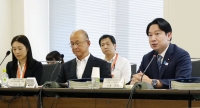 Masanobu Ogura (right), minister in charge of policies for children, speaks during a meeting of an experts' panel held Tuesday in Tokyo to discuss a planned system to require people seeking jobs related to children to submit certificates proving that they have no record of sex crimes. | Kyodo