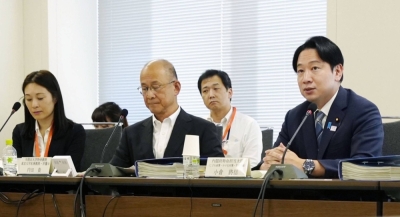 Masanobu Ogura (right), minister in charge of policies for children, speaks during a meeting of an experts' panel held Tuesday in Tokyo to discuss a planned system to require people seeking jobs related to children to submit certificates proving that they have no record of sex crimes.