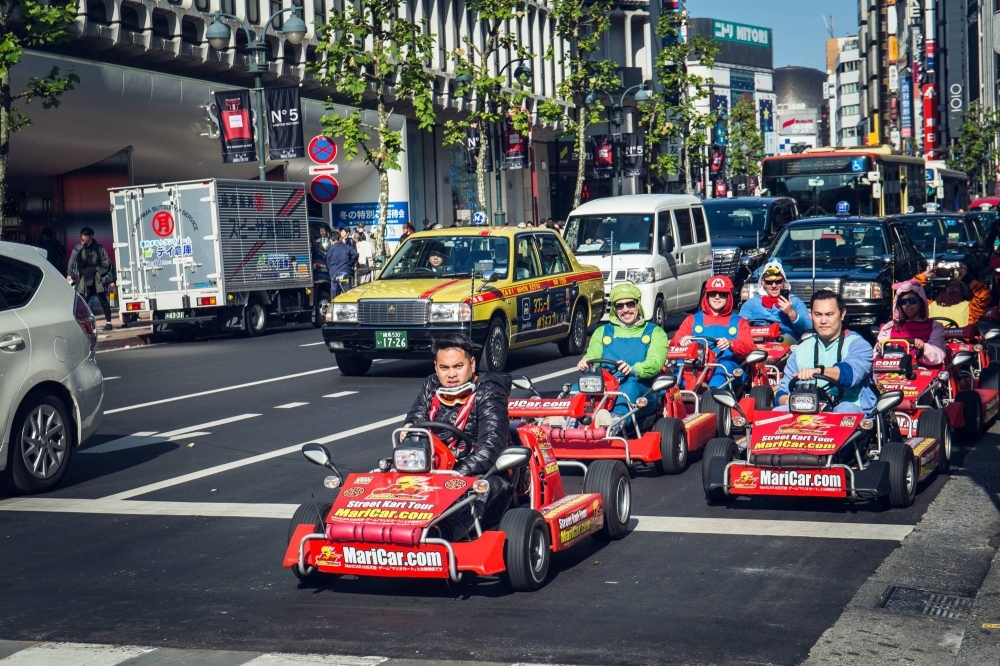 Tourists drive rental go-karts while dressed up as game characters through the streets of Shibuya and other areas of Tokyo in December 2018. 