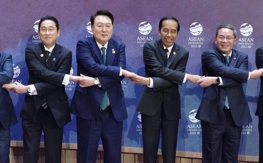 Prime Minister Fumio Kishida, South Korean President Yoon Suk-yeol, Indonesian President Joko Widodo and Chinese Premier Li Qiang hold hands for a commemorative photo during the ASEAN Plus Three meeting in Jakarta on Wednesday.