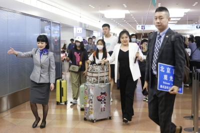 An All Nippon Airways employee escorts a group of Chinese tourists through Haneda Airport in Tokyo last month.