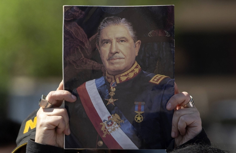 A supporter of Chilean dictator Augusto Pinochet holds a portrait of him during a demonstration in Santiago in 2018.