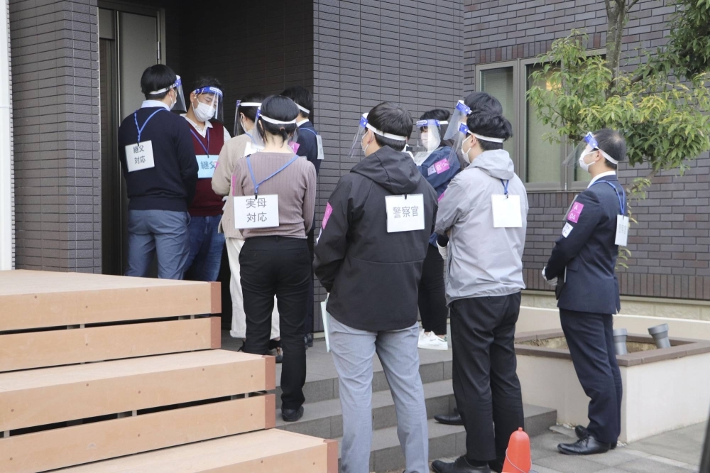 Officers of Chiba Prefectural Police department and child consultation center workers use a model house to conduct joint training in the city of Kimitsu in Chiba Prefecture last November.