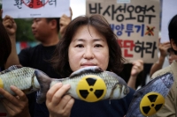 An activist in Seoul protests Japan’s plan to release treated wastewater from the Fukushima No. 1 nuclear plant. | REUTERS