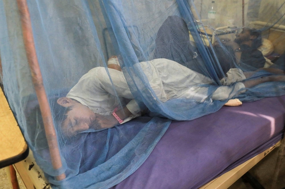 A dengue fever patient lies under a mosquito net inside at Lady Reading Hospital in Peshawar, Pakistan.