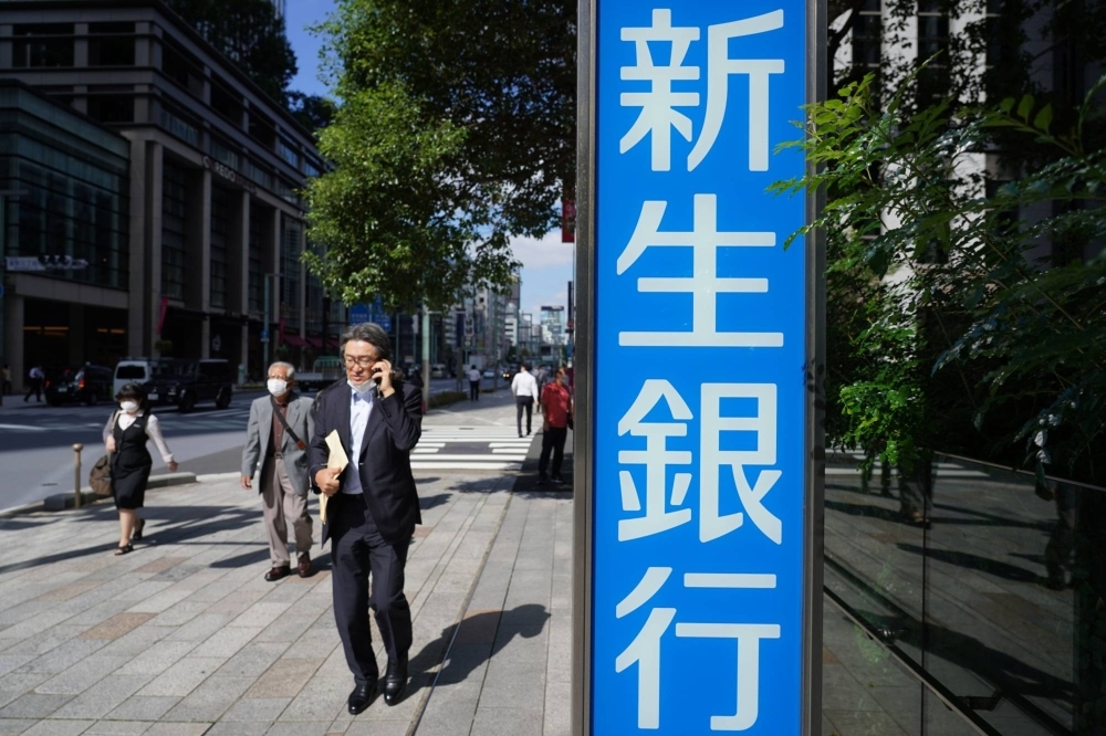 Pedestrians in front of the Shinsei Bank headquarters in Tokyo in October 2021