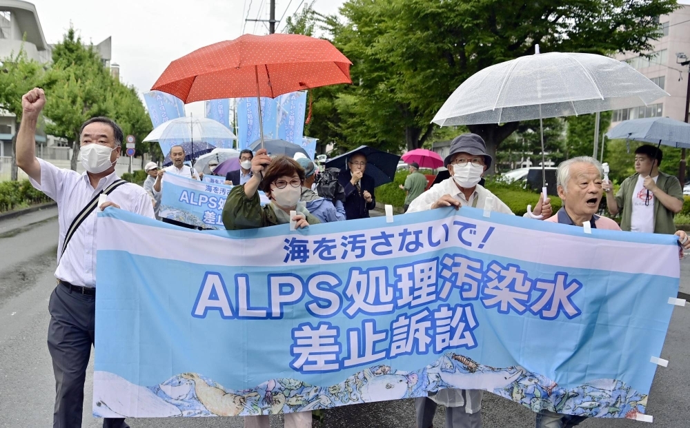A group of plaintiffs for a lawsuit demanding a halt to the release of radioactive water from the Fukushima No. 1 nuclear power plant walk to the Fukushima District Court in the city of Fukushima on Friday.