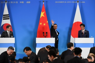 Then-Chinese Premier Li Keqiang waves as he leaves a joint news conference with then-Prime Minister Shinzo Abe and then-South Korean President Moon Jae-in at the last trilateral leaders' meeting between China, South Korea and Japan, in Chengdu, China, in December 2019. 
