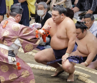 Hoshoryu receives his winnings after defeating Abi on the opening day of the Autumn Grand Sumo Tournament at Tokyo's Ryogoku Kokugikan on Sunday.