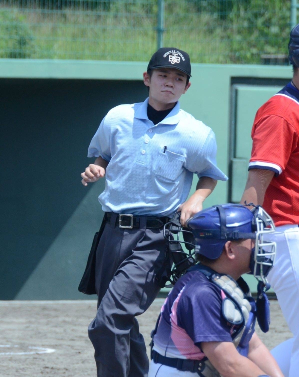 Ren Matsumoto, 18, serves as an umpire at a baseball game.